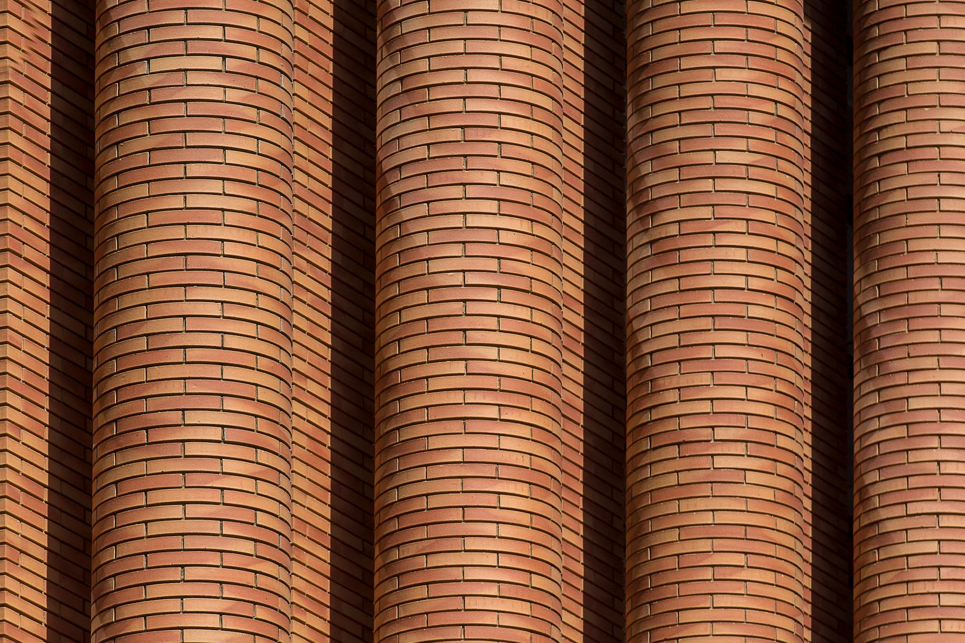 Modernaus namo fasadas padengtas rudomis klinkerio plytelėmis.